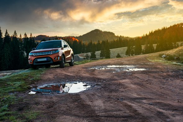 an SUV parked in the countryside in the UK at sunset